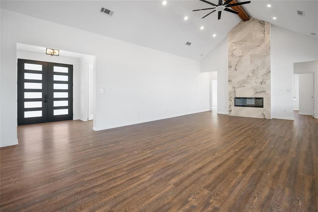 3093 Willow Road Celeste, TX 75423 - Photo 10 of 40 an empty room with wooden floor fireplace and windows
