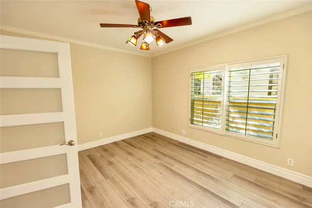 a view of an empty room with a window and a ceiling fan
