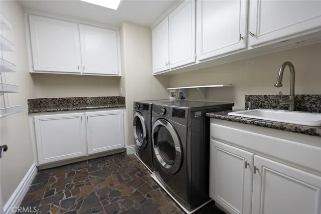a utility room with sink dryer and washer