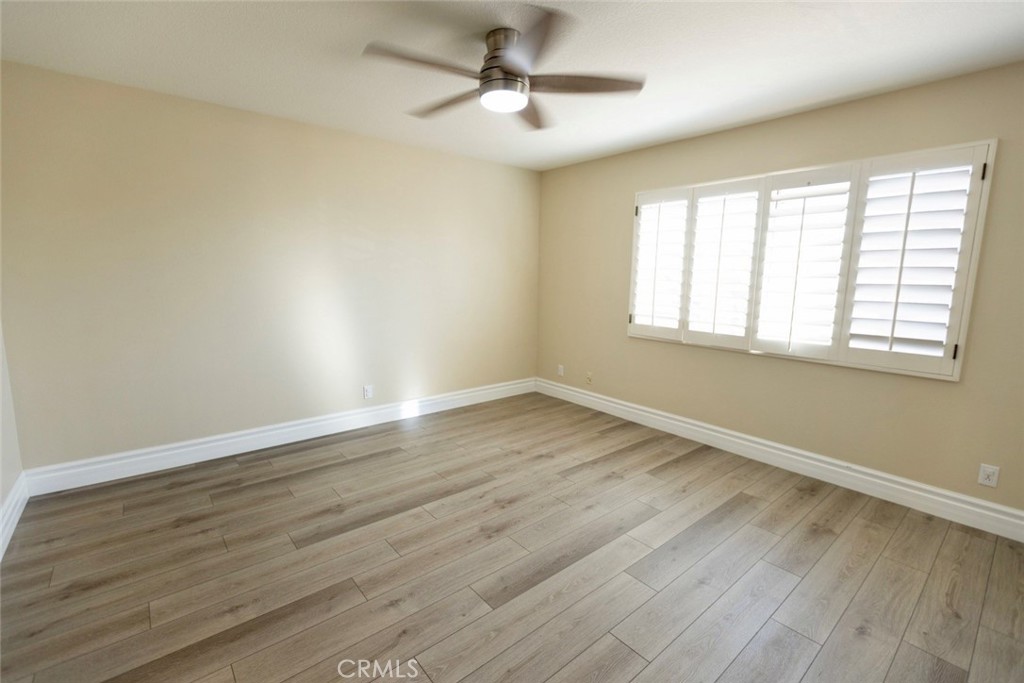 2605 Augusta Tustin, CA 92782 - Photo 36 of 44 an empty room with wooden floor ceiling fan and windows