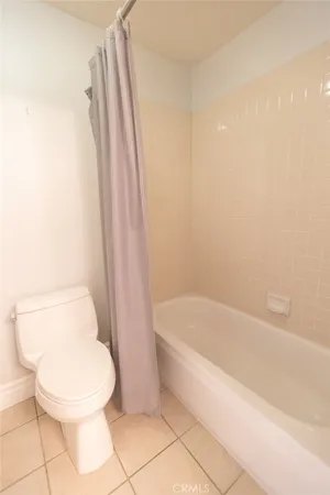 a white toilet sitting next to a bath tub