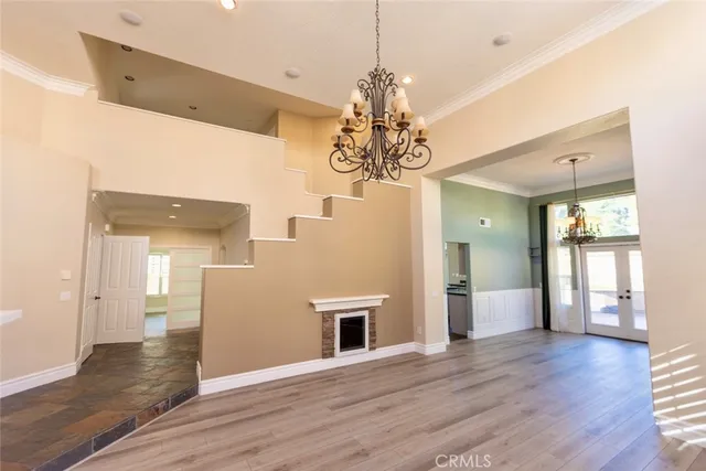 a view of a hallway with wooden floor and chandelier