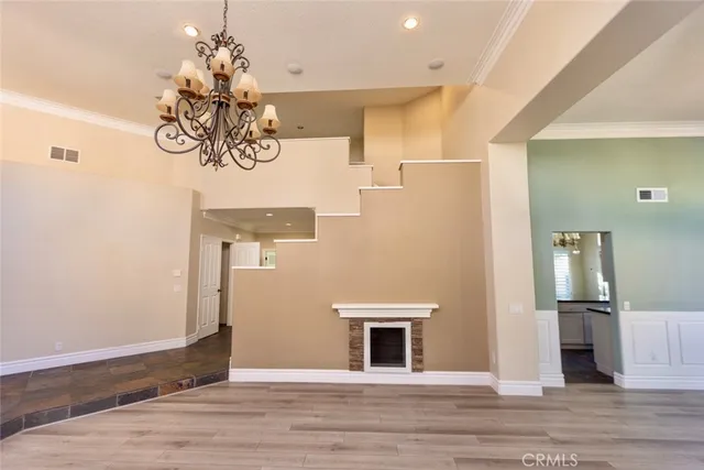 a view of kitchen with stainless steel appliances wooden floor and chair