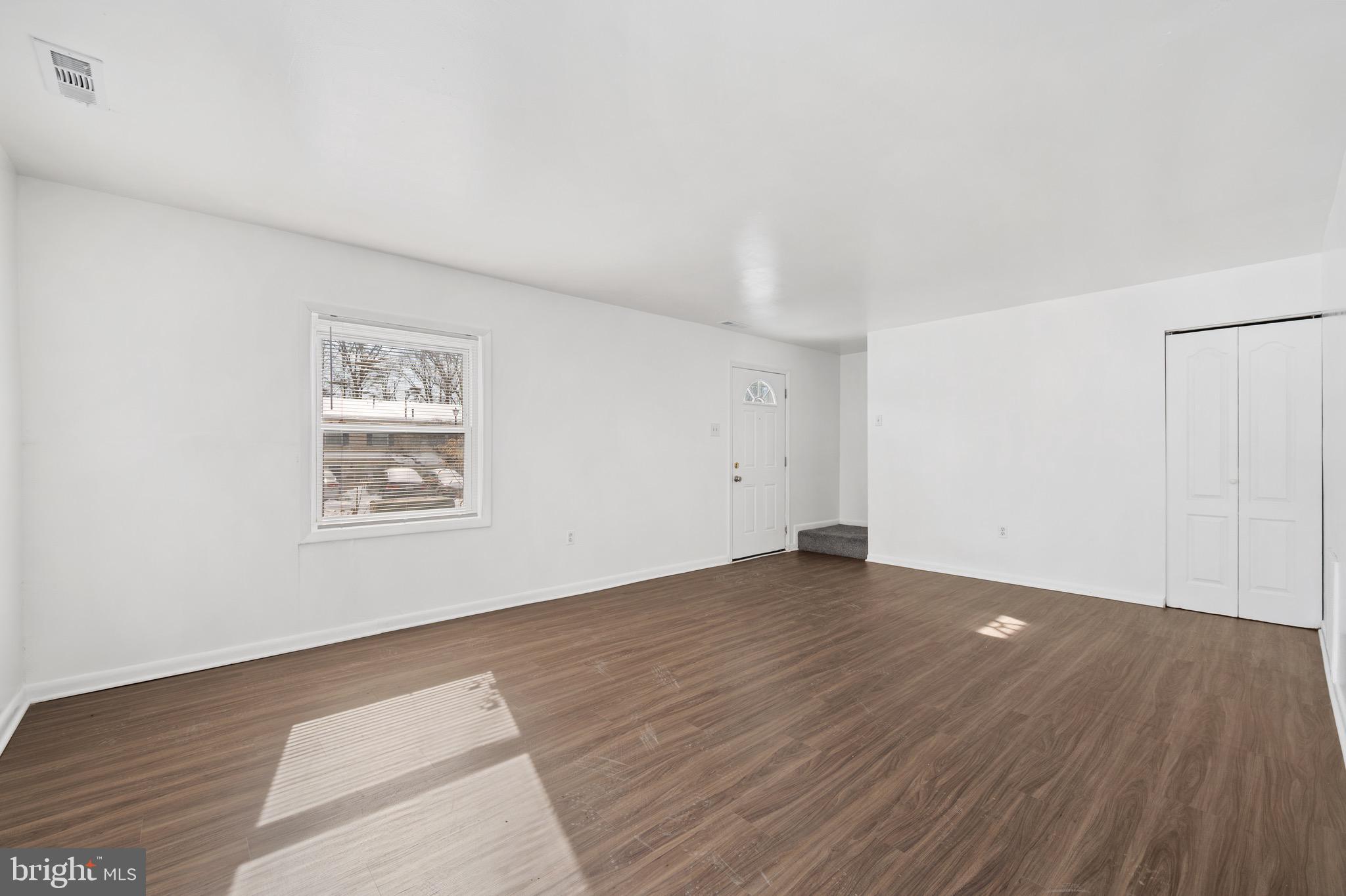 9640 Homestead Court, Unit F Laurel, MD 20723 - Photo 3 of 14 an empty room with wooden floor and windows