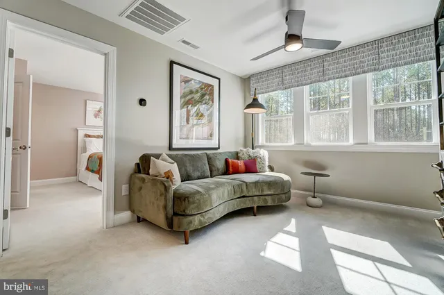 a living room with furniture and a ceiling fan