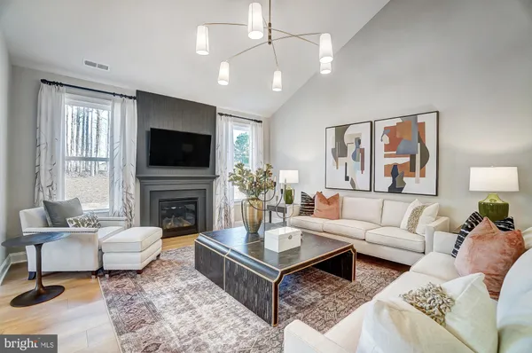 a living room with furniture a fireplace and a flat screen tv