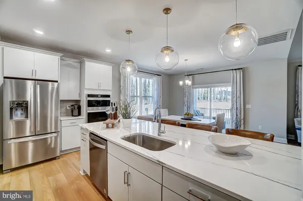 a kitchen with granite countertop a sink appliances and cabinets