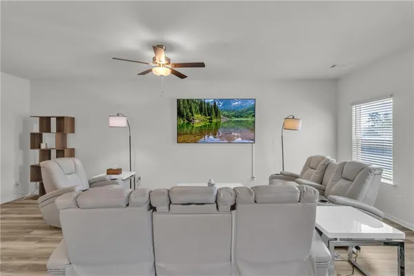 a living room with furniture and a ceiling fan