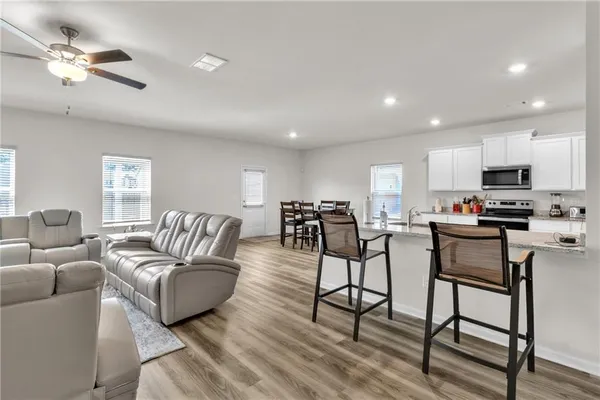 a living room with furniture kitchen view and a chandelier