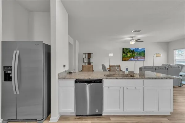 a kitchen with granite countertop a sink stove and cabinets