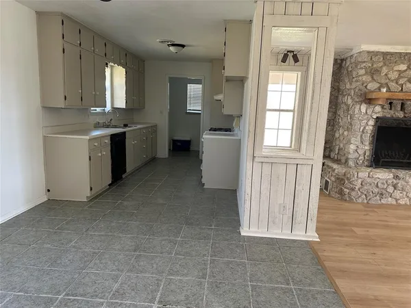 a view of a kitchen with a sink and a fireplace