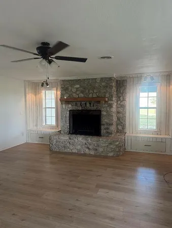a view of empty room with wooden floor and fireplace