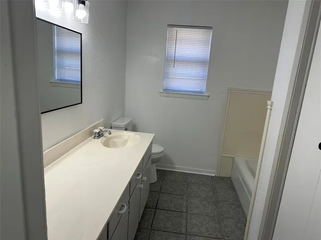 a bathroom with a sink a toilet and mirror
