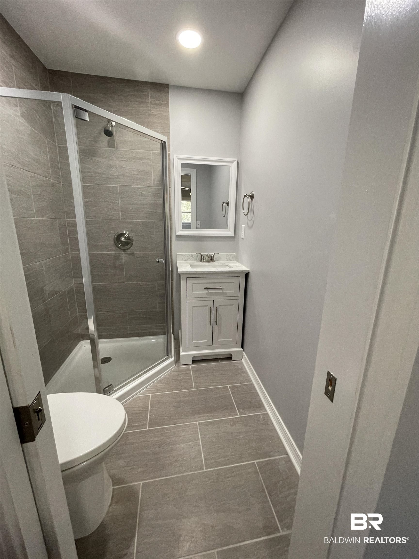 3901 Prima Vera Lane Mobile, AL 36605 - Photo 11 of 15 Bathroom featuring vanity, toilet, and a shower with shower door