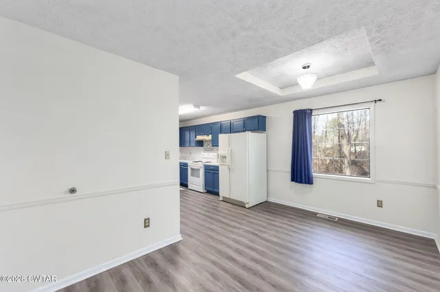 a view of empty room with wooden floor and window