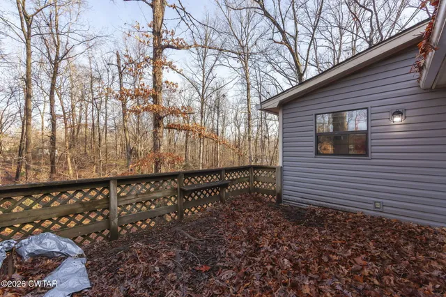 a view of a yard with wooden fence