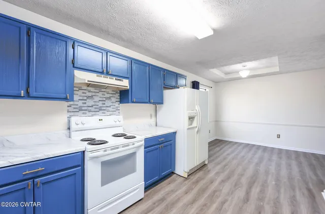 a kitchen with wooden cabinets and white appliances