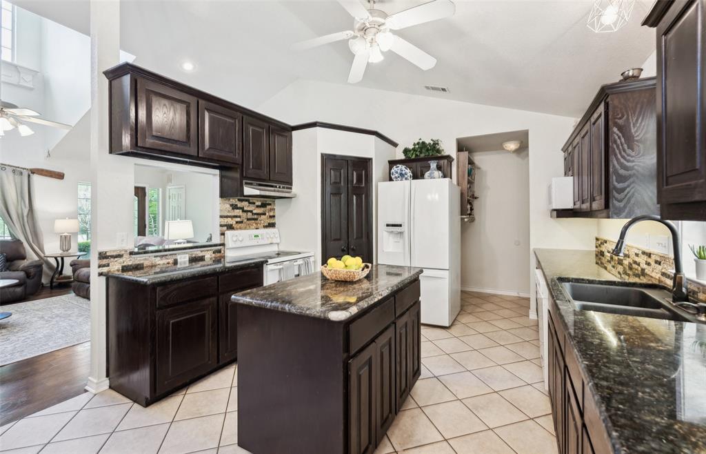 1000 Ballard Road Van Alstyne, TX 75495 - Photo 16 of 40 a kitchen with stainless steel appliances granite countertop a stove a sink and a refrigerator