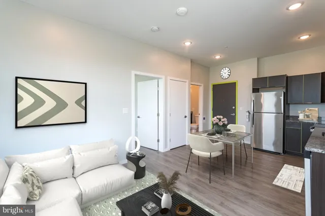 a living room with furniture wooden floor and a refrigerator
