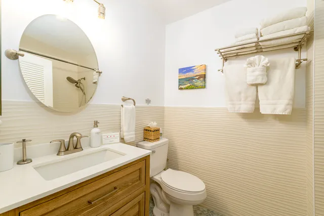 a bathroom with a sink vanity mirror and toilet