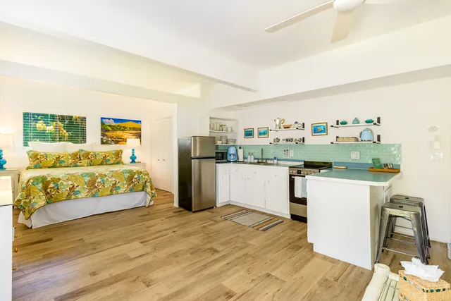 a kitchen with a refrigerator and wooden floor