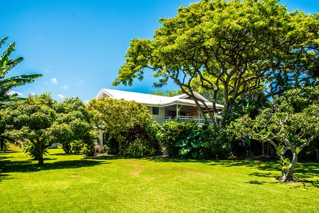 a view of a swimming pool with lawn chairs under an umbrella