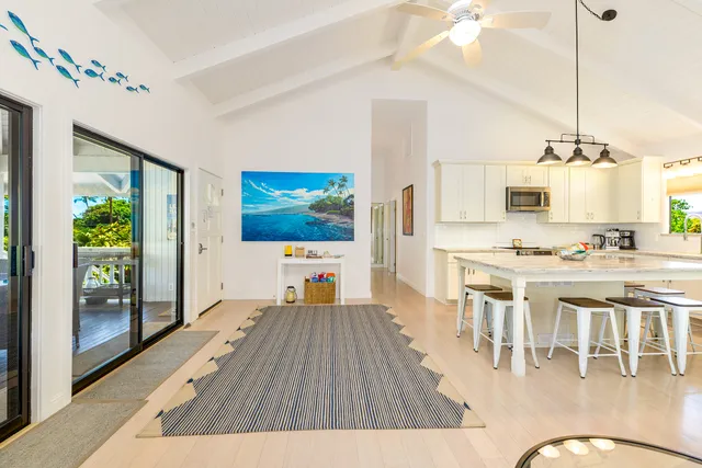 a open kitchen with stainless steel appliances granite countertop a stove top oven a dining table and chairs with wooden floor