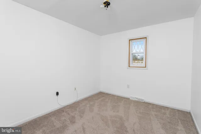 an empty room with wooden floor and wall painting