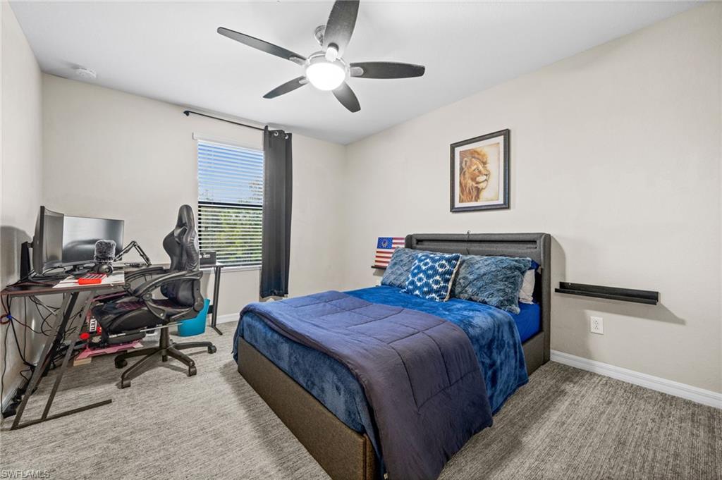 4754 Abaca Circle Naples, FL 34119 - Photo 26 of 46 a bedroom with a bed a desk and chair