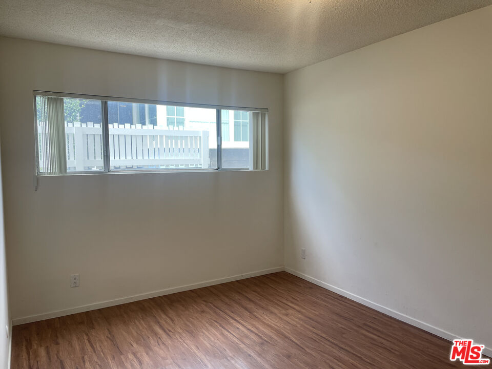 1150 North Commonwealth Avenue, Unit 1 Los Angeles, CA 90029 - Photo 11 of 11 wooden floor in an empty room with a window