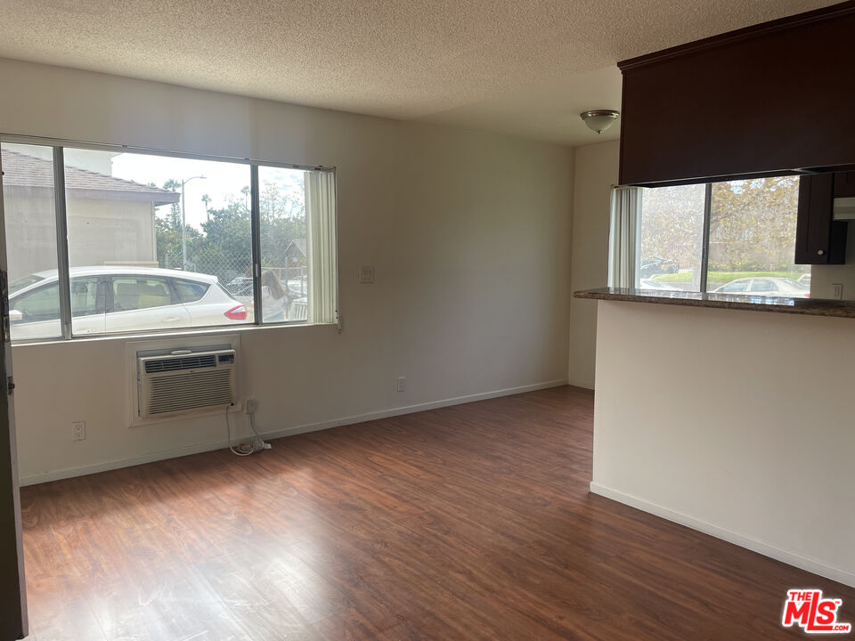 1150 North Commonwealth Avenue, Unit 1 Los Angeles, CA 90029 - Photo 4 of 11 an empty room with wooden floor and windows