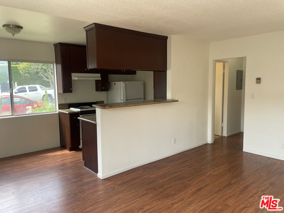 1150 North Commonwealth Avenue, Unit 1 Los Angeles, CA 90029 - Photo 5 of 11 a kitchen with stainless steel appliances a stove a microwave a sink and wooden floors