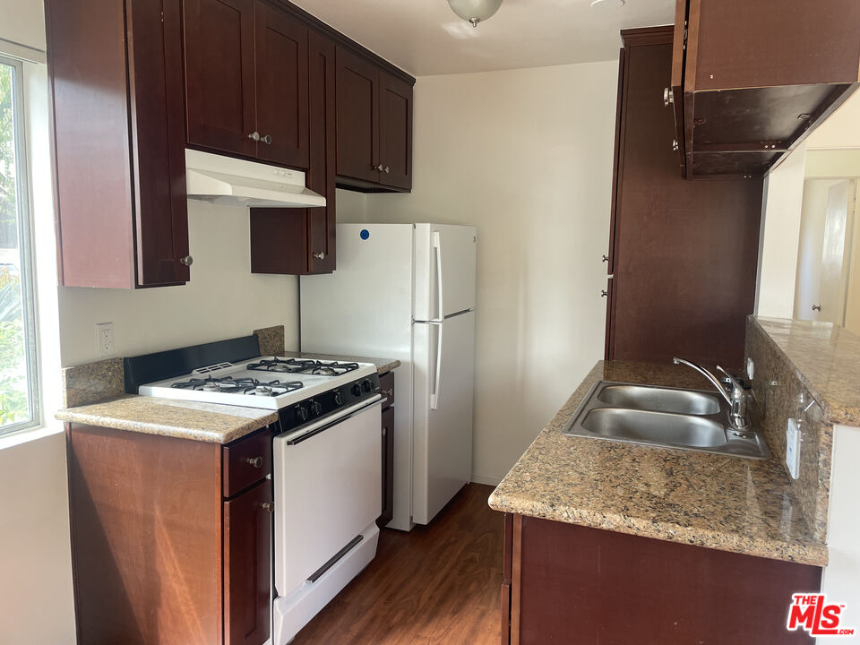 1150 North Commonwealth Avenue, Unit 1 Los Angeles, CA 90029 - Photo 7 of 11 a kitchen with stainless steel appliances granite countertop a sink stove and refrigerator