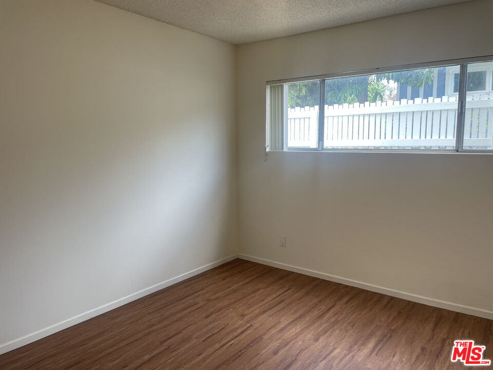 1150 North Commonwealth Avenue, Unit 1 Los Angeles, CA 90029 - Photo 10 of 11 an empty room with wooden floor and windows