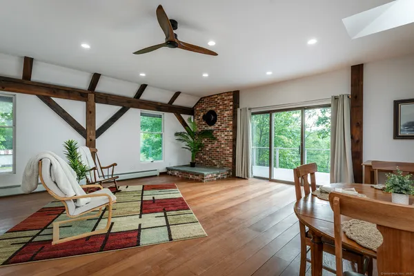 a living room with furniture floor to ceiling window and wooden floor