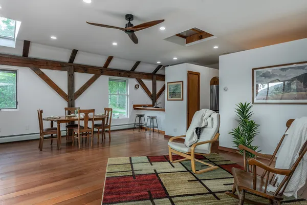 a dining room with wooden floor a glass table and chairs