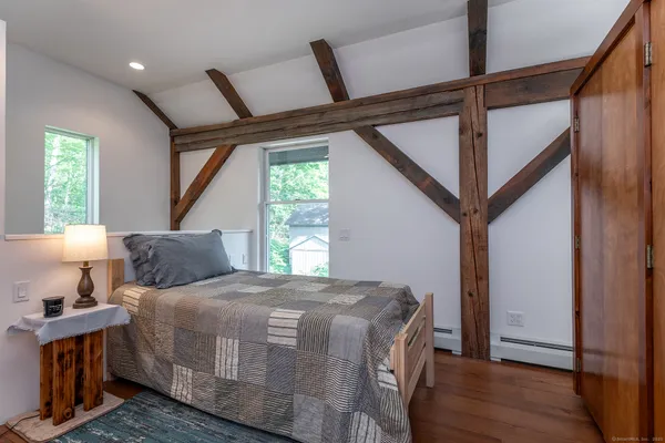 a bedroom with bed and wooden floor