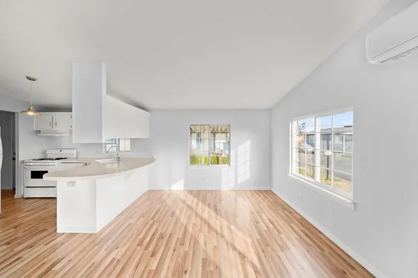 a view of a kitchen with wooden floor and electronic appliances