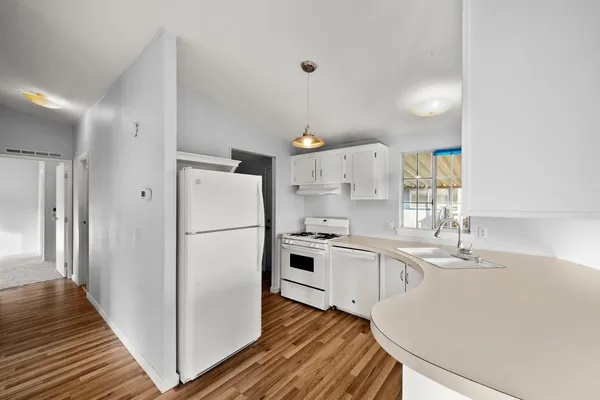 a kitchen with white cabinets and white appliances