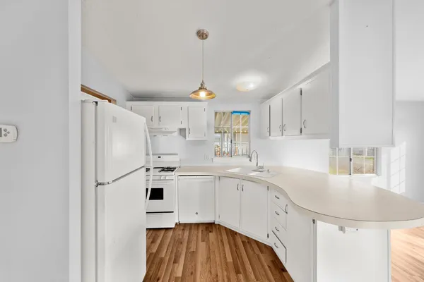 a kitchen with white cabinets and white appliances