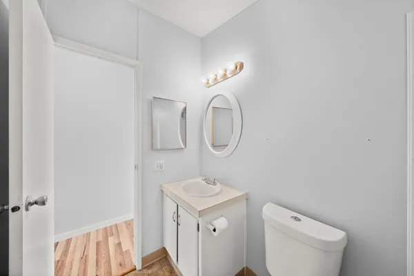 a bathroom with a toilet a sink a mirror and a window