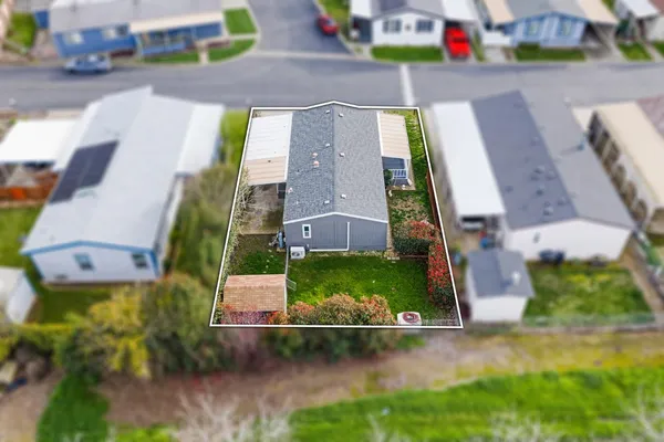 an aerial view of a house with a yard and a large parking space