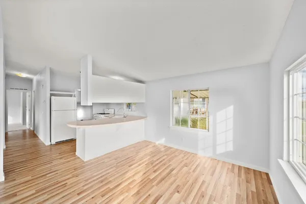 a view of a kitchen and wooden floor