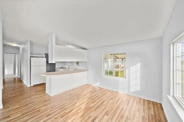a view of a kitchen with wooden floor and a window