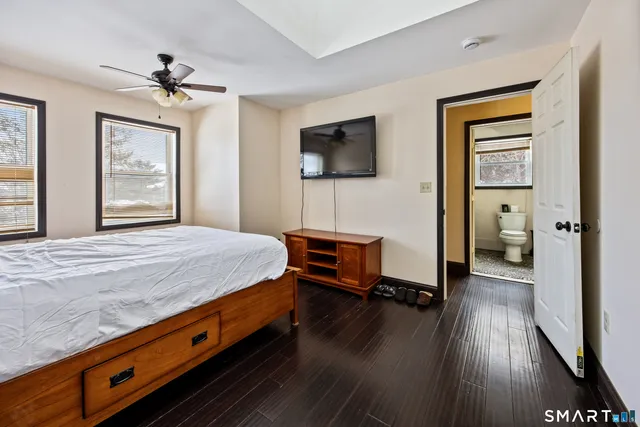 a spacious bedroom with a bed and a flat screen tv