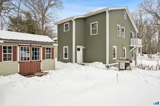a front view of a house with a yard covered in snow