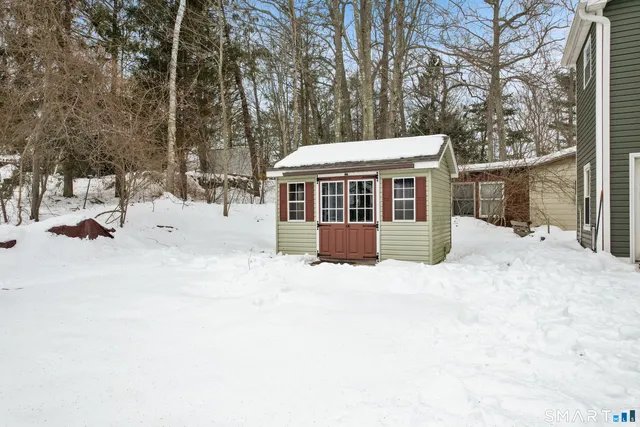 a view of a house with a yard covered in snow