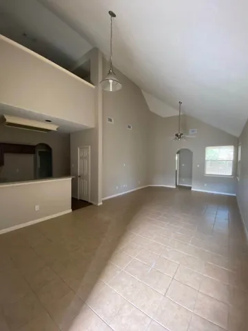 a view of empty room with window and ceiling fan