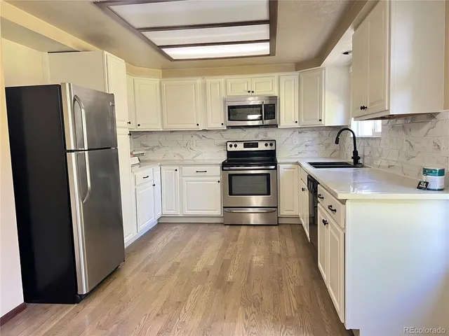 a kitchen with stainless steel appliances a refrigerator sink and microwave