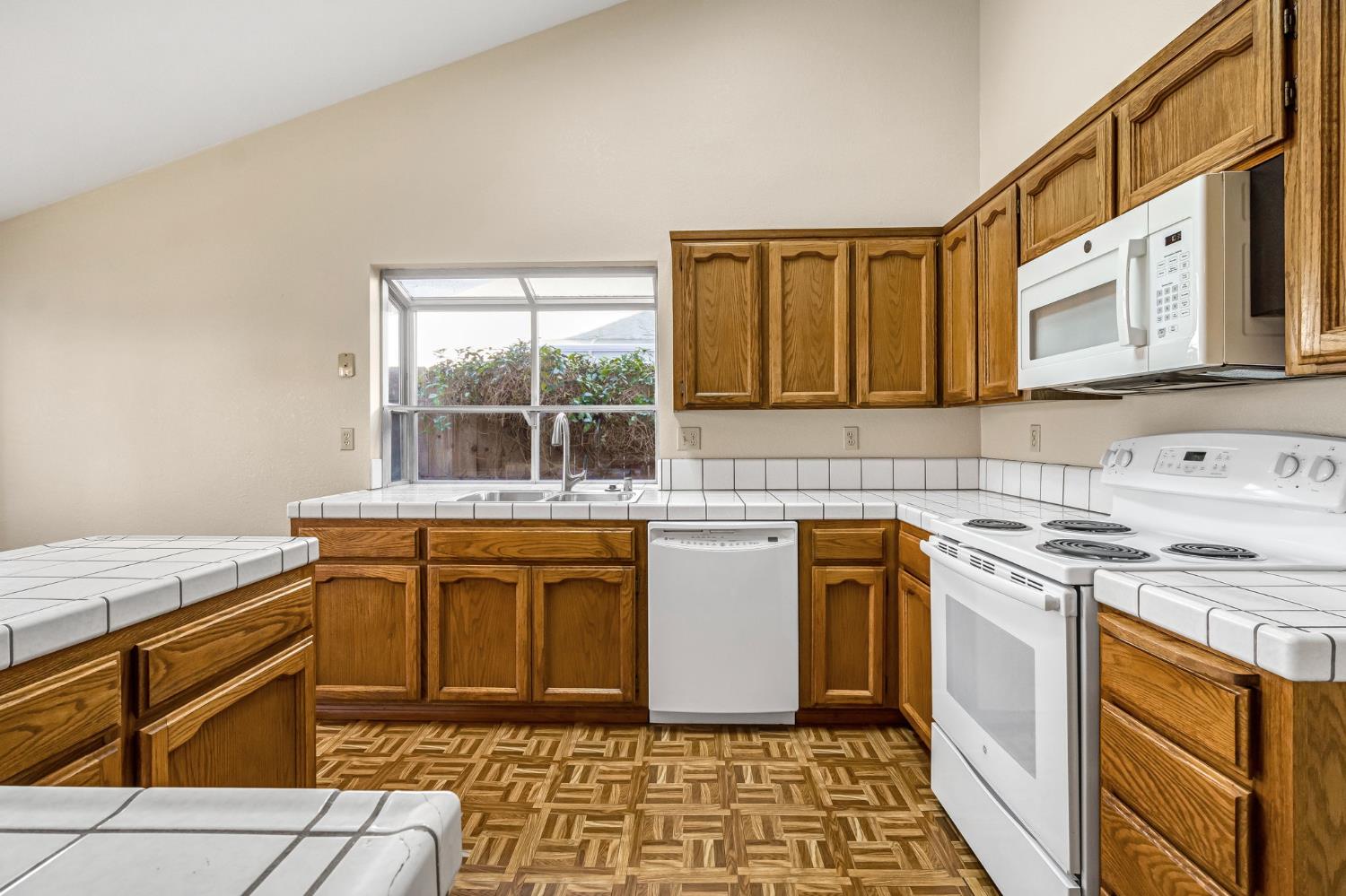 3837 North State Street Fresno, CA 93722 - Photo 16 of 33 a kitchen with stainless steel appliances granite countertop a stove a sink and a microwave